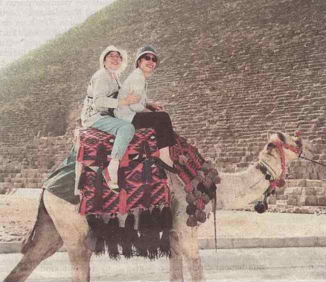 Kamel mit Touristen vor Pyramide